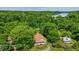 Gorgeous aerial view of a home surrounded by mature trees with a lake and dam in the distance at 5625 Church Rd, Graham, NC 27253