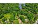 Aerial view of a forested area with homes nearby a body of water at 5625 Church Rd, Graham, NC 27253