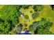 Aerial view of a landscaped lot with mature trees and a storage shed with a house nearby at 5625 Church Rd, Graham, NC 27253