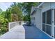 Back deck featuring wood flooring, white railing, table and chairs, as well as blue retractable awning at 5625 Church Rd, Graham, NC 27253
