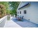 Back deck featuring wood flooring, white railing, table and chairs, as well as blue retractable awning at 5625 Church Rd, Graham, NC 27253