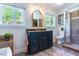 Bathroom with granite-topped vanity and framed mirror with decorative shower and commode at 5625 Church Rd, Graham, NC 27253