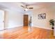 Sunlit bedroom with ceiling fan, hardwood floors, and a glimpse of the kitchen at 5625 Church Rd, Graham, NC 27253