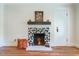 Living area featuring a modern fireplace with unique tile design, wooden mantle and a white door at 5625 Church Rd, Graham, NC 27253