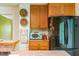 Kitchen showcasing classic cabinetry, a microwave and black fridge, and decorative wall art at 5625 Church Rd, Graham, NC 27253