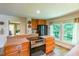 Well-lit kitchen featuring wood cabinets, modern appliances, and a bright window overlooking the outdoors at 5625 Church Rd, Graham, NC 27253