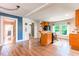 Bright kitchen with wooden cabinetry, stainless steel appliances, and view into other rooms at 5625 Church Rd, Graham, NC 27253