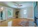 Spacious living room with wood flooring, a decorative rug, ceiling fan, fireplace, and an exterior door at 5625 Church Rd, Graham, NC 27253