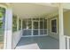 Covered screened porch featuring classic railing, ceiling fans and an ideal outdoor space at 5625 Church Rd, Graham, NC 27253