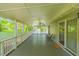 Spacious screened porch featuring ceiling fans, exterior lights, and classic white railing at 5625 Church Rd, Graham, NC 27253