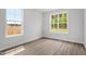 Bright bedroom featuring wood-look flooring and a view of the outdoors through two large windows at 60 Bold Dr, Youngsville, NC 27596