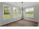 Bright dining room with wood floors and a modern chandelier, illuminated by three large windows at 60 Bold Dr, Youngsville, NC 27596