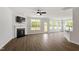 Bright living room with a fireplace, ceiling fan, and an adjacent kitchen with breakfast bar seating at 60 Bold Dr, Youngsville, NC 27596