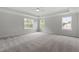 Expansive main bedroom with a tray ceiling, plush carpeting, and ample natural light from three windows at 60 Bold Dr, Youngsville, NC 27596