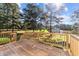 Outdoor deck with wooden railings overlooking a green yard and mature trees at 620 Richardson Rd, Zebulon, NC 27597