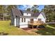 Rear view of the home featuring a wood deck, lawn and mature trees in the backyard at 620 Richardson Rd, Zebulon, NC 27597
