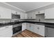 Updated kitchen featuring stainless steel appliances, black granite countertops, and white cabinetry at 620 Richardson Rd, Zebulon, NC 27597