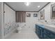 Beautiful bathroom featuring double sinks with a tiled floor and floral shower curtain at 6447 Beulah Church Rd, Liberty, NC 27298