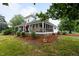 Charming farmhouse with a wrap-around porch, American flag, and beautifully landscaped front yard at 6447 Beulah Church Rd, Liberty, NC 27298