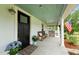 Inviting front porch with comfortable seating, blue hydrangeas and a welcoming bench at 6447 Beulah Church Rd, Liberty, NC 27298