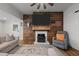 Living room features a wood accent wall with a fireplace, TV, rustic decor, and comfortable seating at 6447 Beulah Church Rd, Liberty, NC 27298