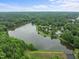 Extensive aerial view of a lake surrounded by lush greenery with homes nestled near the shoreline at 6925 Valley Lake Dr, Raleigh, NC 27612