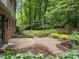 Lush backyard patio with garden beds surrounding the brick area at 6925 Valley Lake Dr, Raleigh, NC 27612