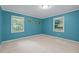 Bright bedroom with large windows and vibrant blue walls at 6925 Valley Lake Dr, Raleigh, NC 27612