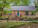 Charming brick home featuring a beautifully landscaped front yard and a vibrant teal front door at 6925 Valley Lake Dr, Raleigh, NC 27612