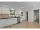 Well-lit kitchen features white cabinets, stainless steel appliances, and tile flooring at 6925 Valley Lake Dr, Raleigh, NC 27612