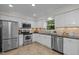 Well-lit kitchen featuring stainless steel appliances and white cabinetry at 6925 Valley Lake Dr, Raleigh, NC 27612