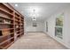 Spacious living room with built-in bookshelves, large windows, and plush carpeting at 6925 Valley Lake Dr, Raleigh, NC 27612