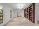 Bright living room with a large bookshelf and carpet flooring at 6925 Valley Lake Dr, Raleigh, NC 27612