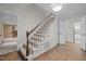Interior staircase with wood railing, white spindles, and carpeted steps leading to the upper level at 6925 Valley Lake Dr, Raleigh, NC 27612