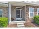 Inviting front porch with a stone accent wall, a gray door, and a well-manicured garden at 711 Keystone Park Dr # 7, Morrisville, NC 27560