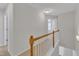 Upstairs hallway featuring a carpeted floor and wooden railing leading to the bedrooms and bathrooms at 711 Keystone Park Dr # 7, Morrisville, NC 27560