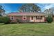 Charming brick home with a well-maintained lawn and mature trees on a sunny day at 713 Marlboro Pl, Rocky Mount, NC 27801