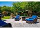 Expanded patio with stone sitting wall, outdoor seating, and lush landscaping at 740 Blackfriars Loop, Cary, NC 27519