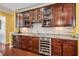 Elegant wet bar with granite countertop, wine rack, stainless steel cooler and glass door cabinets at 740 Blackfriars Loop, Cary, NC 27519