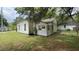 Rear view of a small, dated house with visible wear, complemented by lush green grass at 752 Nashville Rd, Rocky Mount, NC 27803