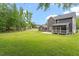 Large backyard view of the house, garage, screened in porch, and luscious green grass at 852 Cokesbury Park Lane Ln, Fuquay Varina, NC 27526