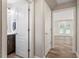 Hallway with gray vinyl flooring and white doors leading to a bathroom and a room with glass doors at 852 Cokesbury Park Lane Ln, Fuquay Varina, NC 27526