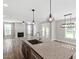 Open concept kitchen overlooking living room with granite countertops, island, and modern lighting at 852 Cokesbury Park Lane Ln, Fuquay Varina, NC 27526