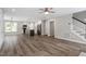 Open-concept living area featuring modern vinyl floors, a sleek kitchen, and a staircase at 852 Cokesbury Park Lane Ln, Fuquay Varina, NC 27526
