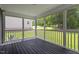 Cozy screened-in porch with wooded view and dark stained wood flooring at 852 Cokesbury Park Lane Ln, Fuquay Varina, NC 27526