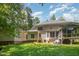 View of the home's backyard with a well-maintained lawn, a patio, and mature trees at 8840 Woodyhill Rd, Raleigh, NC 27613