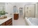 Bathroom features tub, glass enclosed shower, wood cabinets, and tile floor at 8840 Woodyhill Rd, Raleigh, NC 27613