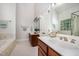 Well-lit bathroom showcases wood cabinets, tile floors, and soaking tub at 8840 Woodyhill Rd, Raleigh, NC 27613