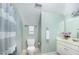 This bathroom features blue walls, a toilet, a vanity with sink, and a shower with a striped curtain at 8840 Woodyhill Rd, Raleigh, NC 27613
