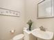 Clean half bath featuring pedestal sink and decorative wall art at 8840 Woodyhill Rd, Raleigh, NC 27613